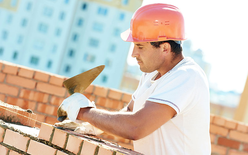 Construction worker laying brick