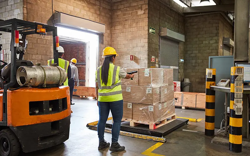 Warehouse worker scanning an inbound pallet with an RFID reader