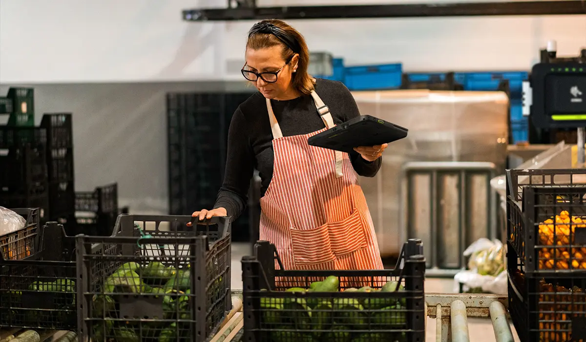 Worker using EdgeMicro to track incoming produce in harvesting facility.